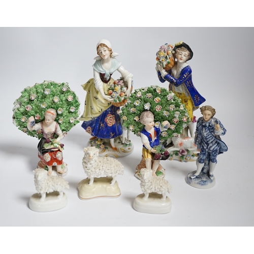 596 - A pair of Derby style porcelain small bocage figures, a boy and girl seated with grape filled hats, ... 