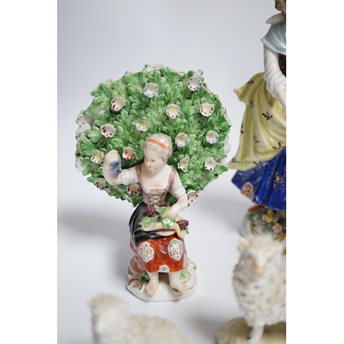 596 - A pair of Derby style porcelain small bocage figures, a boy and girl seated with grape filled hats, ... 