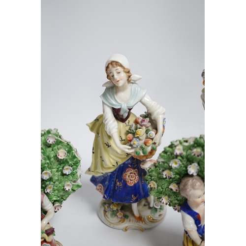 596 - A pair of Derby style porcelain small bocage figures, a boy and girl seated with grape filled hats, ... 