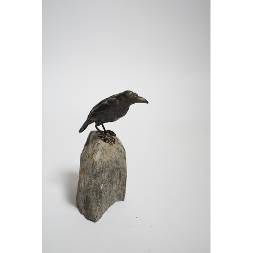 606 - A cold painted bronze crow, raised on a stone base, 10cm high