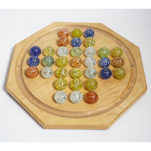 628 - A turned wood solitaire board with multi-coloured glass marbles, 27cm wide