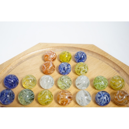 628 - A turned wood solitaire board with multi-coloured glass marbles, 27cm wide