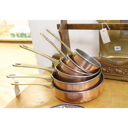 666 - A graduated set of six copper and brass saucepans with beech hanging rack, 104cm wide