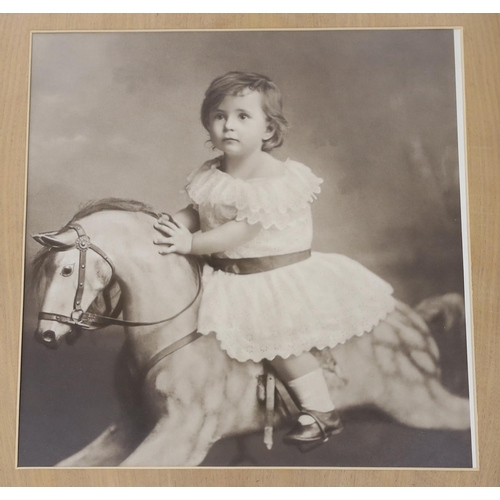 762 - A large photographic print, Infant on rocking horse, housed in a carved frame Russel, 1891, and an... 