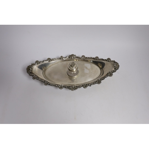 842 - A late Victorian silver navette shaped inkstand, with silver mounted cut glass well, on four reeded ... 