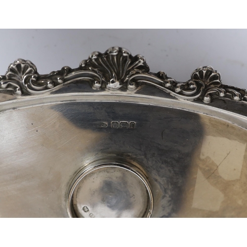 842 - A late Victorian silver navette shaped inkstand, with silver mounted cut glass well, on four reeded ... 