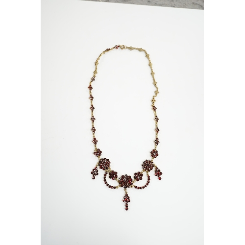 915 - An early 20th century gilt sterling and garnet cluster set drop necklace, 45cm.