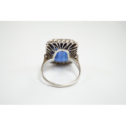 925 - A 1920's white metal and single stone emerald cut synthetic sapphire set dress ring, with millegrain... 