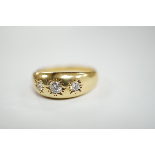 928 - A modern 18ct gold and gypsy set three stone diamond ring, size S, gross weight 7.9 grams.