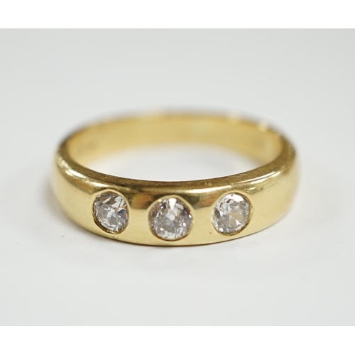 929 - A modern 18ct gold and gypsy set three stone diamond ring, size R, gross weight 7.6 grams.