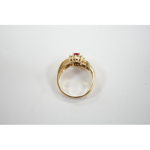 949 - A modern 14k, ruby and diamond set oval cluster dress ring, with diamond chip set shoulders, size P,... 