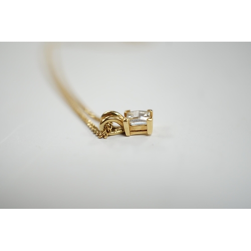 973 - A modern 18ct gold and single stone fancy rectangular cut diamond set pendant, 9mm, on an 18ct gold ... 