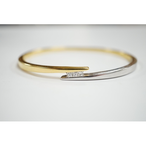 975 - A modern two colour 18k and three stone princess cut diamond set hinged bangle, interior 60mm, gross... 