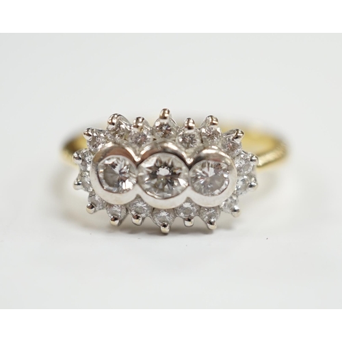 981 - A modern 18ct gold and collet set three stone diamond ring, with diamond chip set border, size J/K, ... 