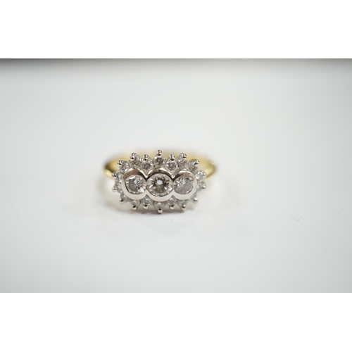 981 - A modern 18ct gold and collet set three stone diamond ring, with diamond chip set border, size J/K, ... 