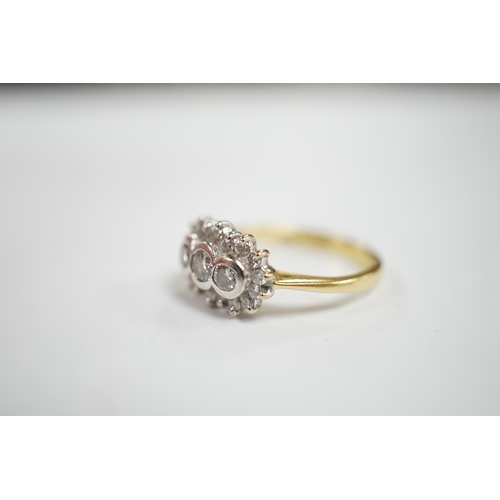 981 - A modern 18ct gold and collet set three stone diamond ring, with diamond chip set border, size J/K, ... 