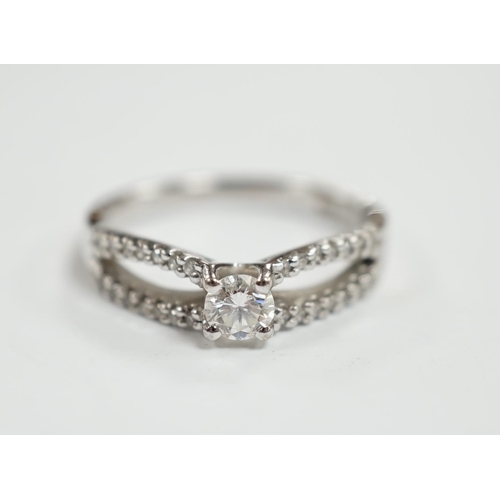 984 - A modern 18ct white gold and single stone diamond set ring, with diamond chip set split shoulders, s... 