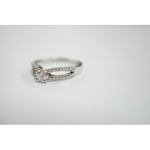 984 - A modern 18ct white gold and single stone diamond set ring, with diamond chip set split shoulders, s... 