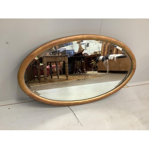 169 - An Edwardian oak pierced frame mirror and an oval wall mirror, larger width 64cm, height 85cm