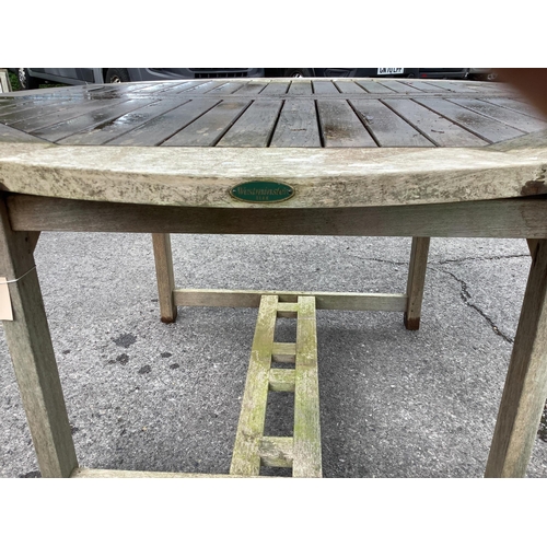 181 - A Westminster circular weathered teak extending garden table, (leaf not functioning correctly) diame... 