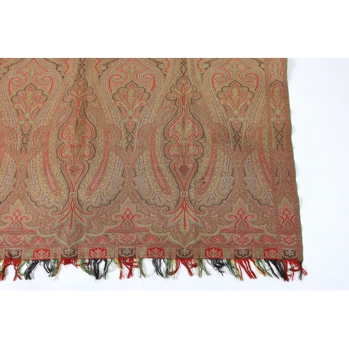 276 - An 1860s, reversible woven wool Paisley shawl, woven with green, red, ochre and brown, with a woven... 