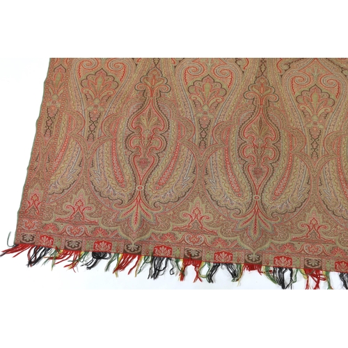 276 - An 1860s, reversible woven wool Paisley shawl, woven with green, red, ochre and brown, with a woven... 