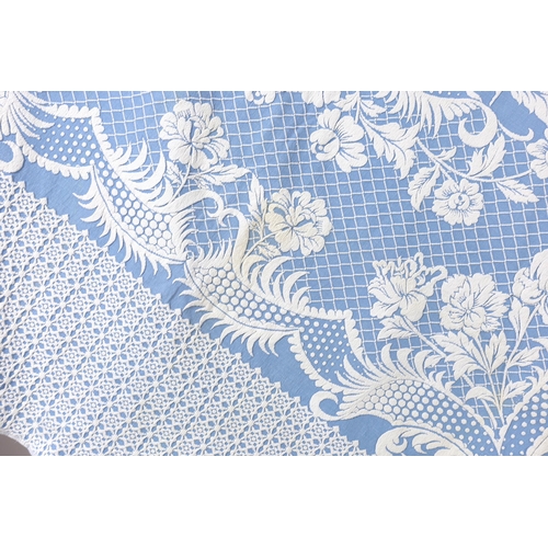 344 - An early 20th century woven 'Marcella' style bed cover, with a blue ground and a white raised floral... 