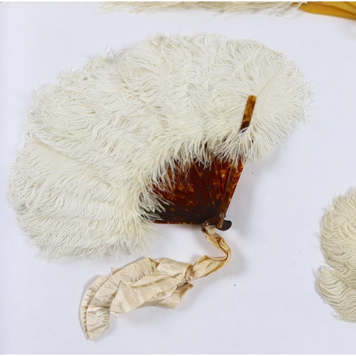 377 - Two early 20th century Ostrich feather and mother of pearl fans, another similar fan with amber Bake... 