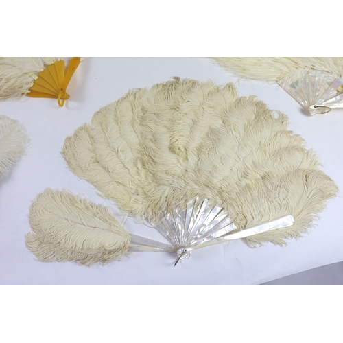 377 - Two early 20th century Ostrich feather and mother of pearl fans, another similar fan with amber Bake... 