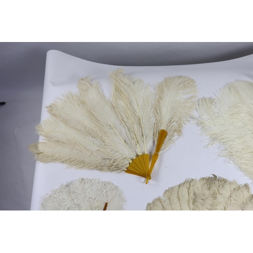 377 - Two early 20th century Ostrich feather and mother of pearl fans, another similar fan with amber Bake... 