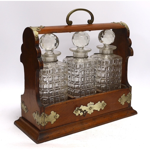 439 - A three bottle tantalus with silver mounts and engraved Masonic presentation, 36cm wide