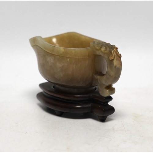 525 - An 18th century Chinese archaistic jade pouring vessel, yi, with carved dragon handle, 6cm high, on ... 