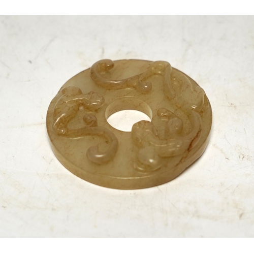 527 - An 18th century Chinese mottled jade bi disc, decorated with two carved chilong, 5.8cm diameter... 