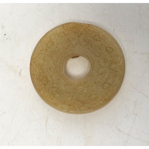 527 - An 18th century Chinese mottled jade bi disc, decorated with two carved chilong, 5.8cm diameter... 