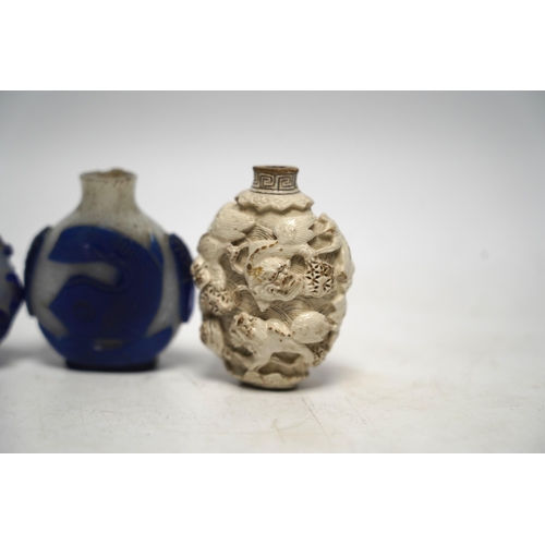 536 - A Chinese moulded and white glazed Buddhist lion snuff bottle, 19th century and three overlaid gla... 