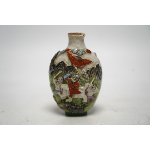 537 - A Chinese moulded in enamelled porcelain figures riding mythical beasts snuff bottle, Qianlong mar... 