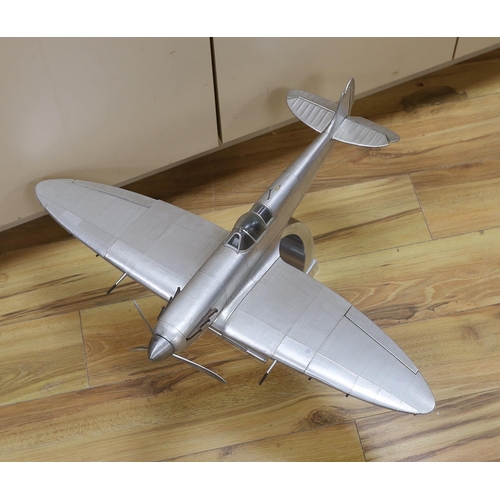 561 - A sheet metal model of a WWII Spitfire on a stand, applied plaque to the base, 60cm in length