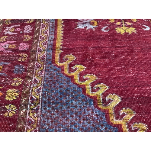 57 - An antique hand knotted Caucasian blue ground prayer rug, 180 x 117cm