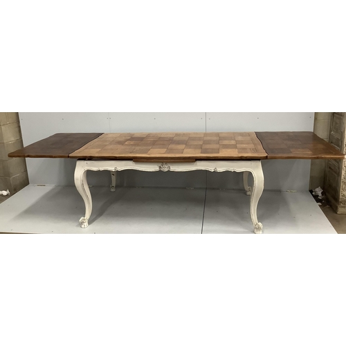 73 - An early 20th century French part painted oak draw leaf extending dining table, width 300cm extended... 