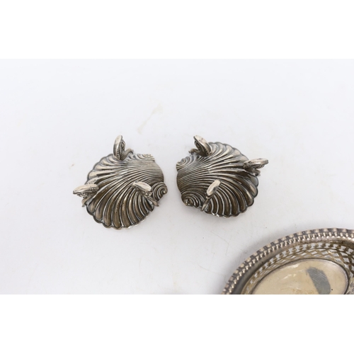 868 - A pair of Victorian silver shell salts, on dolphin supports, London, 1876, 69mm and a two pierced si... 