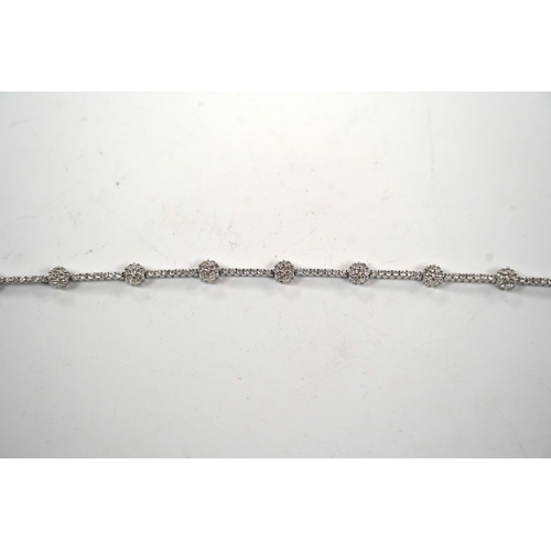 910 - A modern 18k white metal and diamond cluster set line bracelet, 17.8cm, gross weight 8.8 grams.... 