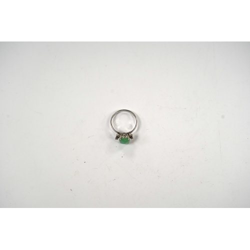 921 - A modern 18k white metal and single stone cabochon jade and six stone diamond chip set ring, size O,... 