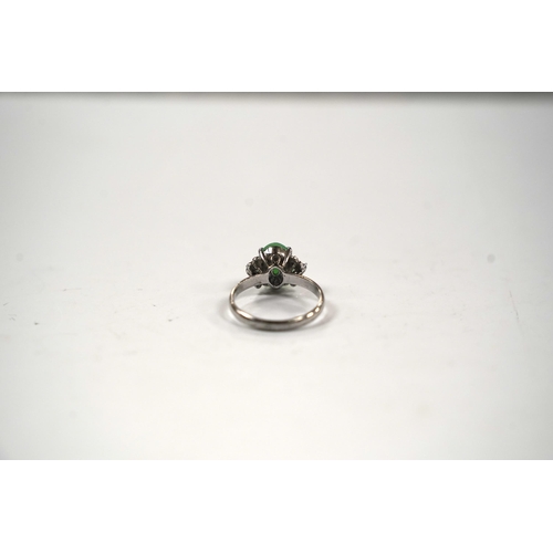 921 - A modern 18k white metal and single stone cabochon jade and six stone diamond chip set ring, size O,... 