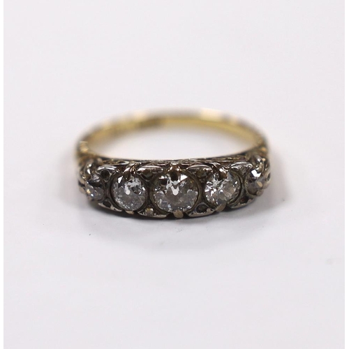 956 - An early 20th century 18ct, plat and graduated five stone diamond set half hoop ring, with diamond c... 