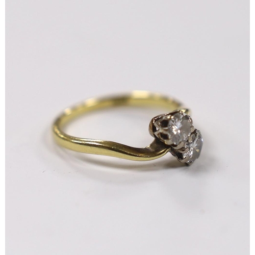 957 - An 18ct and two stone diamond set crossover ring, size M, gross weight 2.8 grams, each stone diamete... 