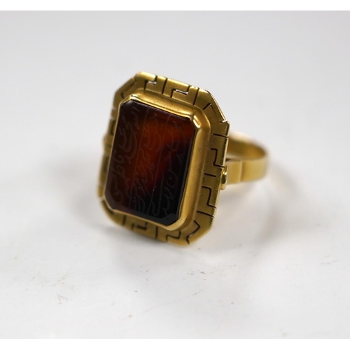 993 - A 14k and carnelian set ring, with pierced border and stone inscribed with Islamic script, size  O, ... 