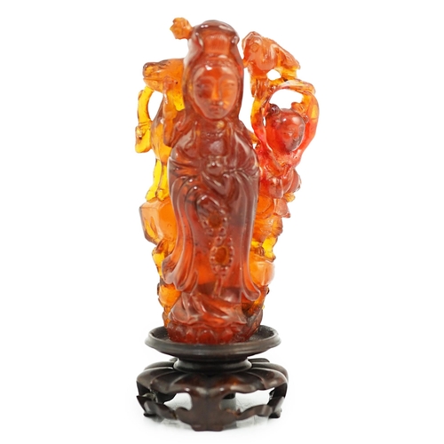 115 - A Chinese amber group of Guanyin, 19th century, carved in high relief and openwork with a figure of ... 