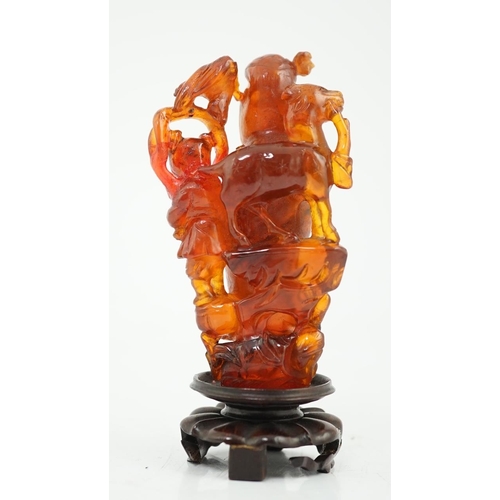 115 - A Chinese amber group of Guanyin, 19th century, carved in high relief and openwork with a figure of ... 