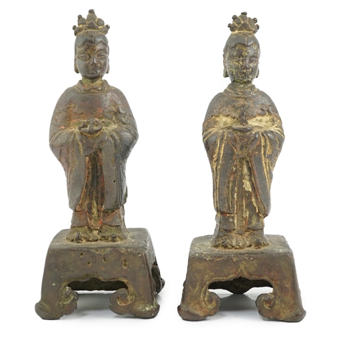 152 - A pair of Chinese Ming bronze figures of attendants, each figure standing and holding an offering in... 