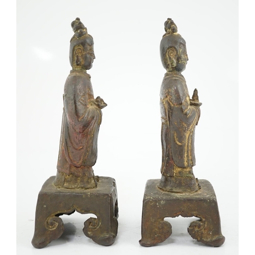 152 - A pair of Chinese Ming bronze figures of attendants, each figure standing and holding an offering in... 